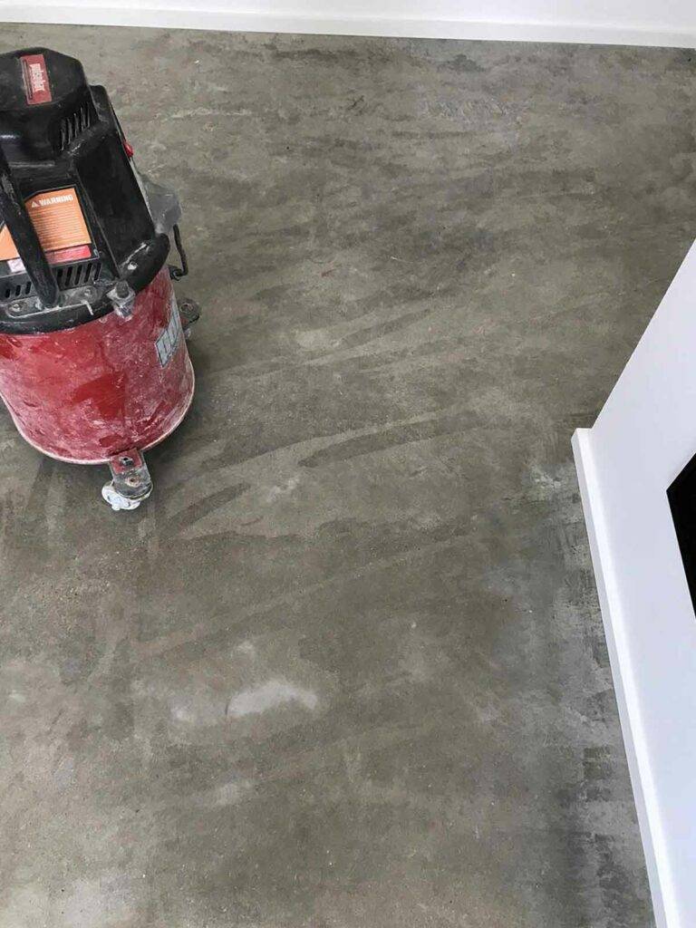 Notice the tiger-striped areas on this luxury residential floor. This sealer has catastrophically failed!  It was installed by a painting company without proper preparation of the slab. Repairing this floor cost about four times what a proper install would have cost, leaving this home owner with a considerable repair bill. 